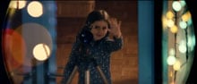 Young girl looking through telescope waves to the man on the moon