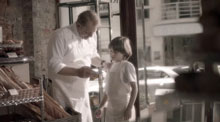 Young boy learning the bakery business from his father